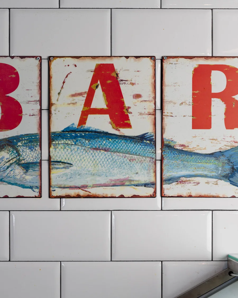 Red signs with a fish motif on the white tile