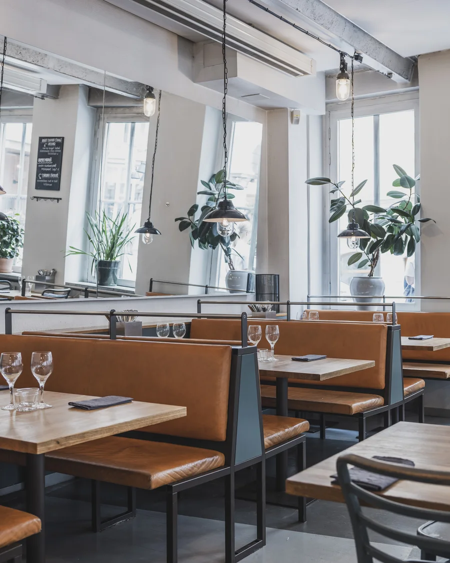 Leather booth seating by the window with potted plants