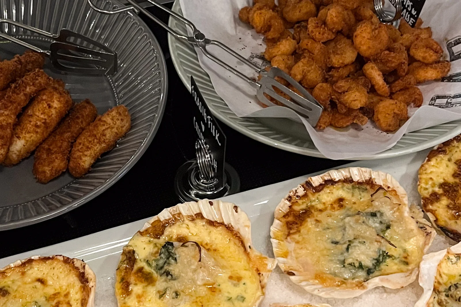 Breaded croquettes, fried pieces in a bowl and gratinated shells on a platter