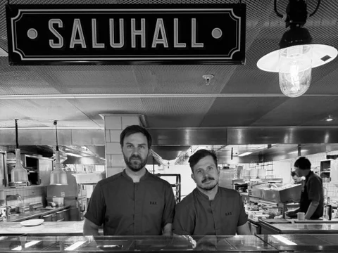 Two chefs behind the fish counter under the SALUHALL sign, labelled fish on ice